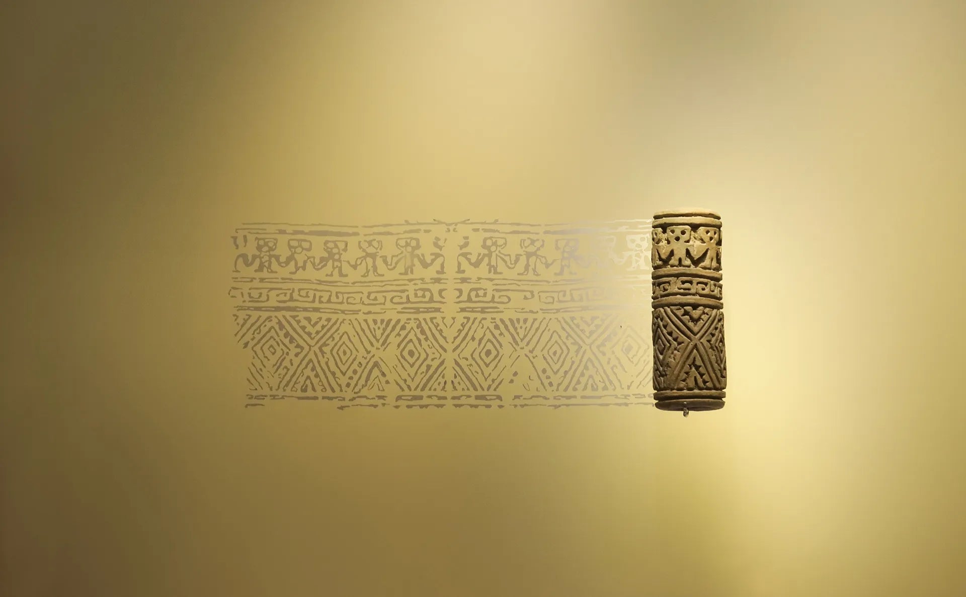 Pre-Colombian carved cylindrical artifact with geometric and anthropomorphic patterns displayed at the Gold Museum, Bogotá, Colombia.
